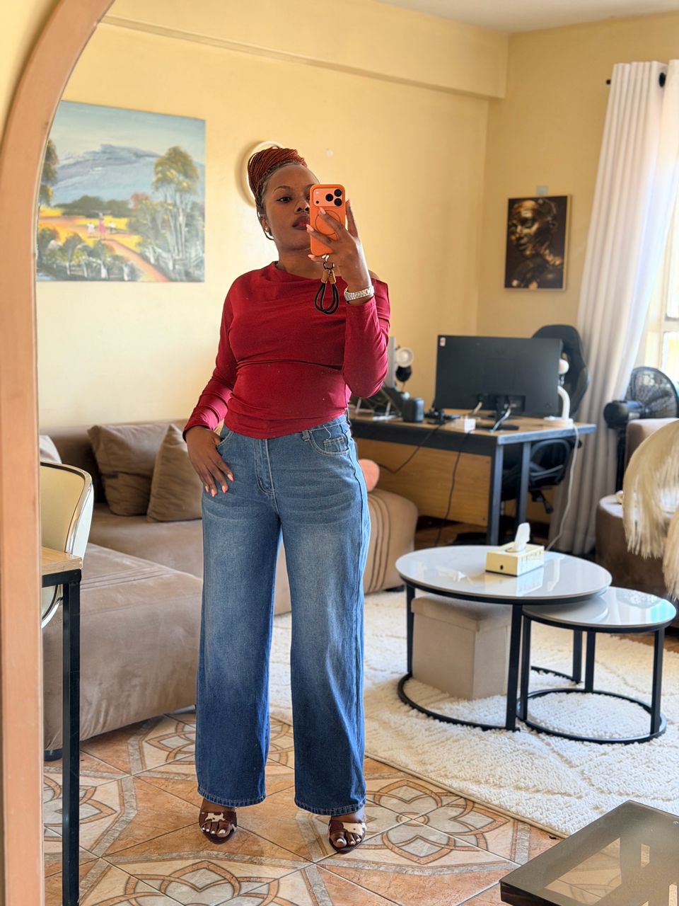 Natalie in a red top taking a mirror selfie