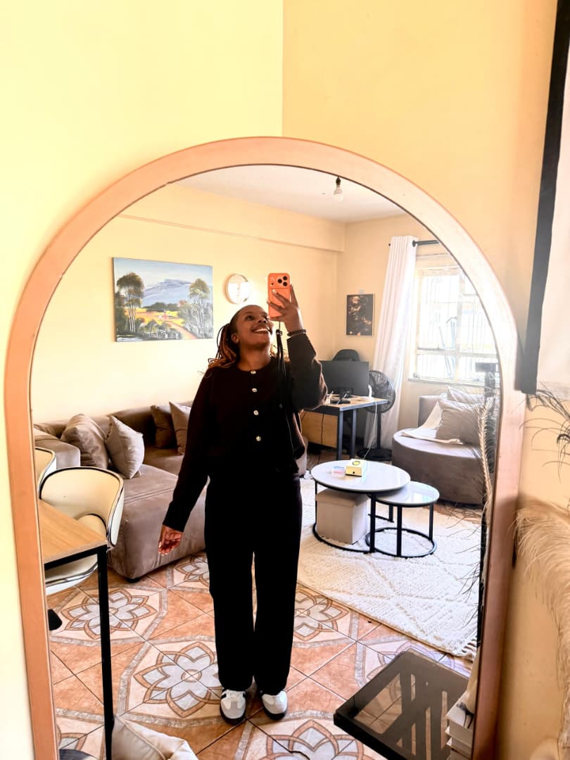 Natalie taking a mirror selfie in a warm sunlit living room